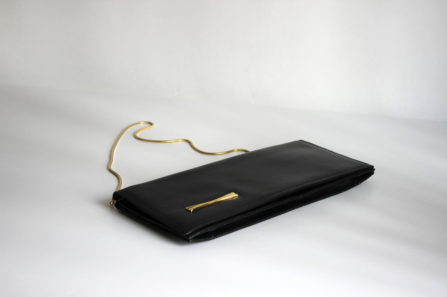 Eris – mid ’80s–early ’90s black calf-leather envelope clutch with gold-tone snake-chain strap
