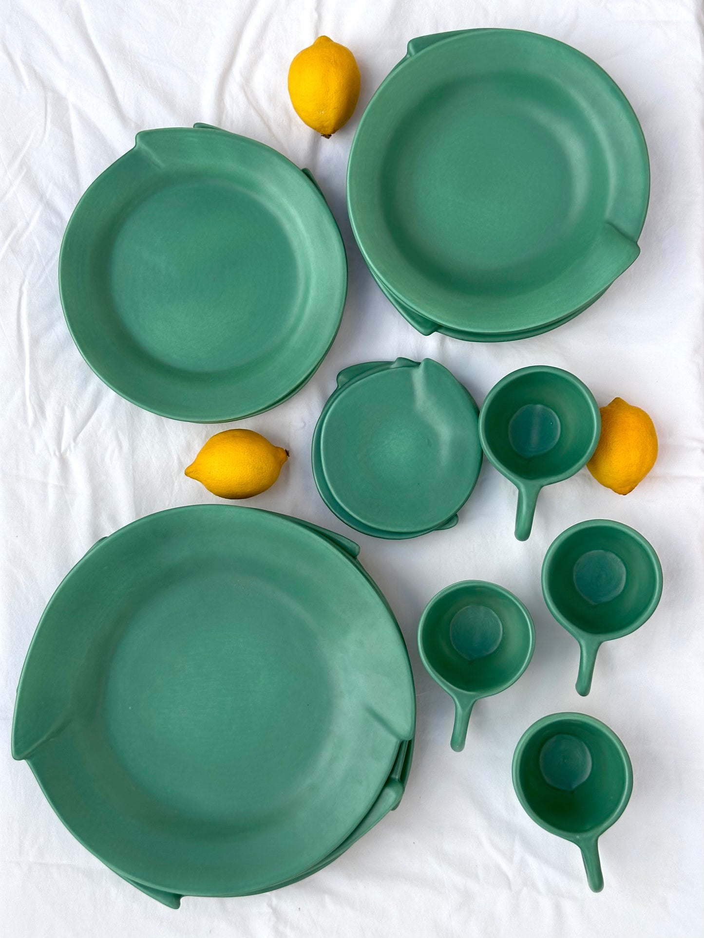 Julie Sanders “Cyclamen” dinnerware set – matte green ceramic, 20-piece, 1990s