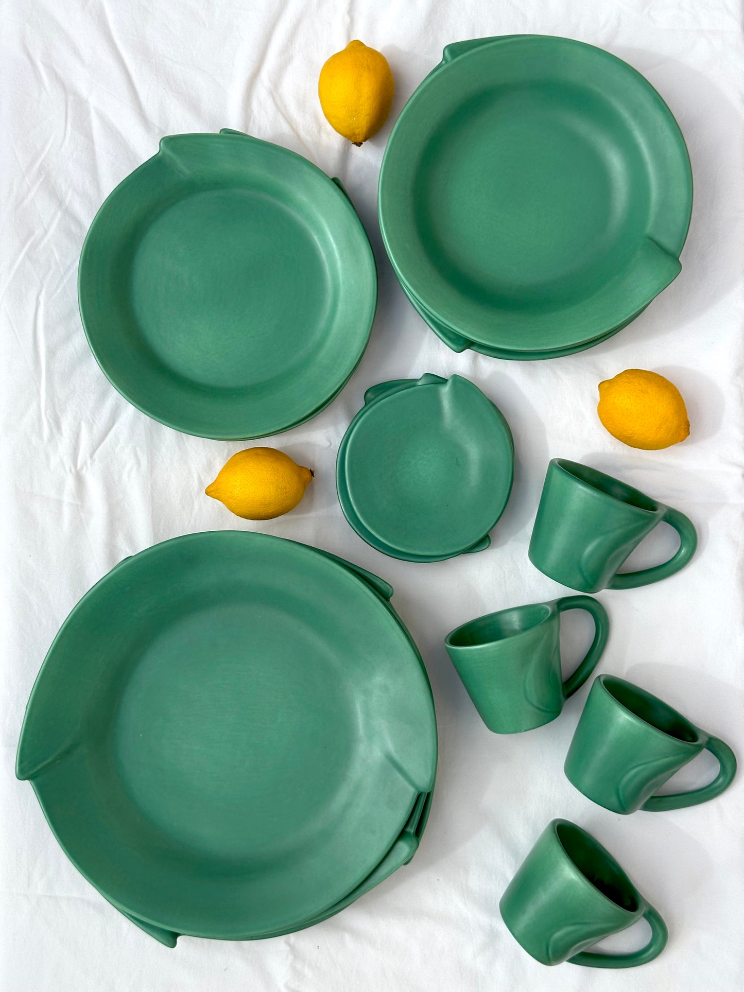 Julie Sanders “Cyclamen” dinnerware set – matte green ceramic, 20-piece, 1990s