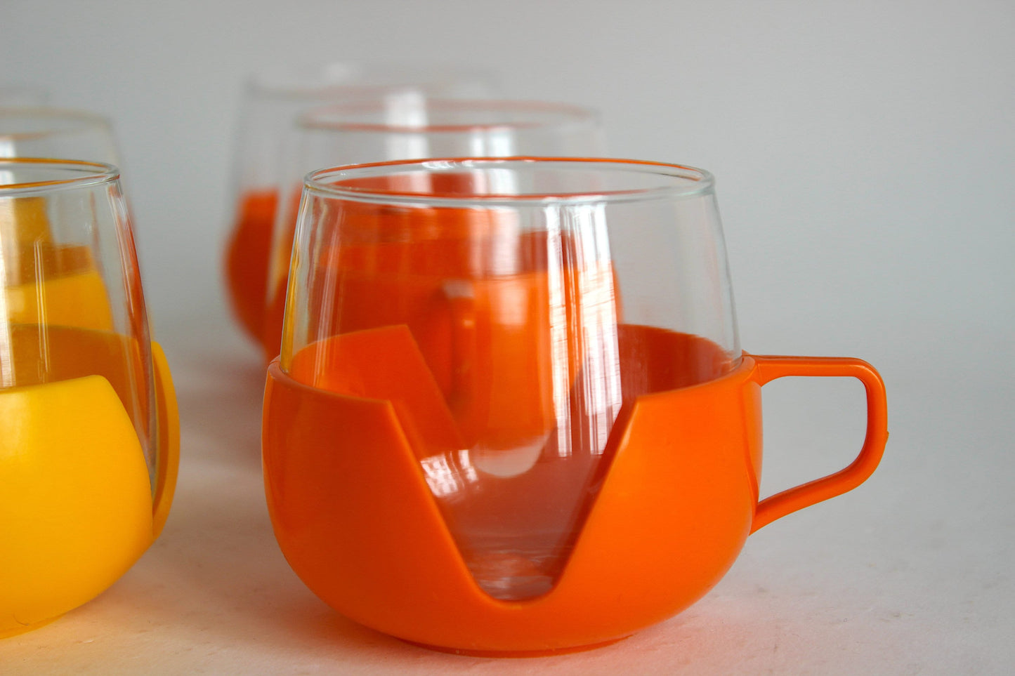 Set of 9 multicolored glass tumblers for tea or coffee with plastic handles - Holland 60s / 70s
