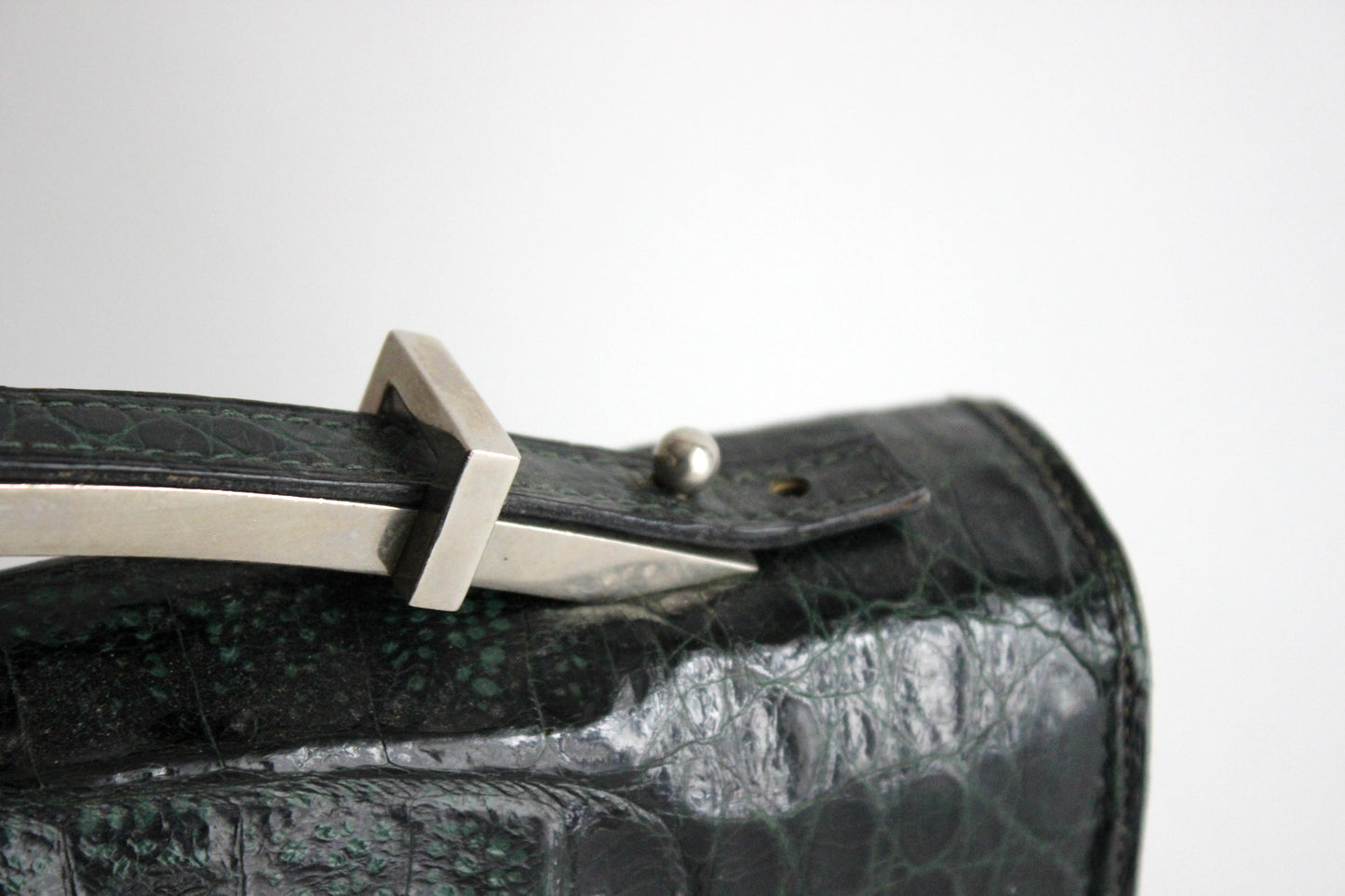 Persephone – early ’70s green-black crocodile-embossed leather clutch with silver-arc handle