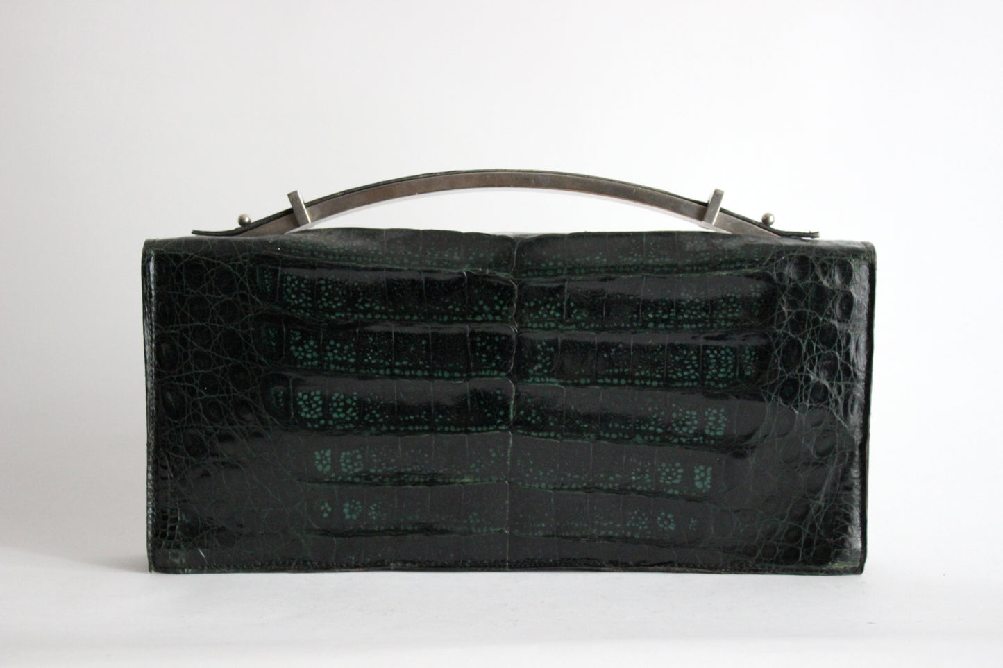 Persephone – early ’70s green-black crocodile-embossed leather clutch with silver-arc handle