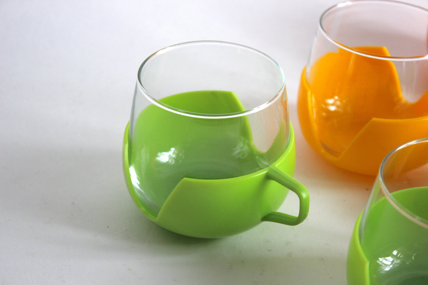 Set of 9 multicolored  glass tumblers for tea or coffee with plastic handles - Holland 60s / 70s